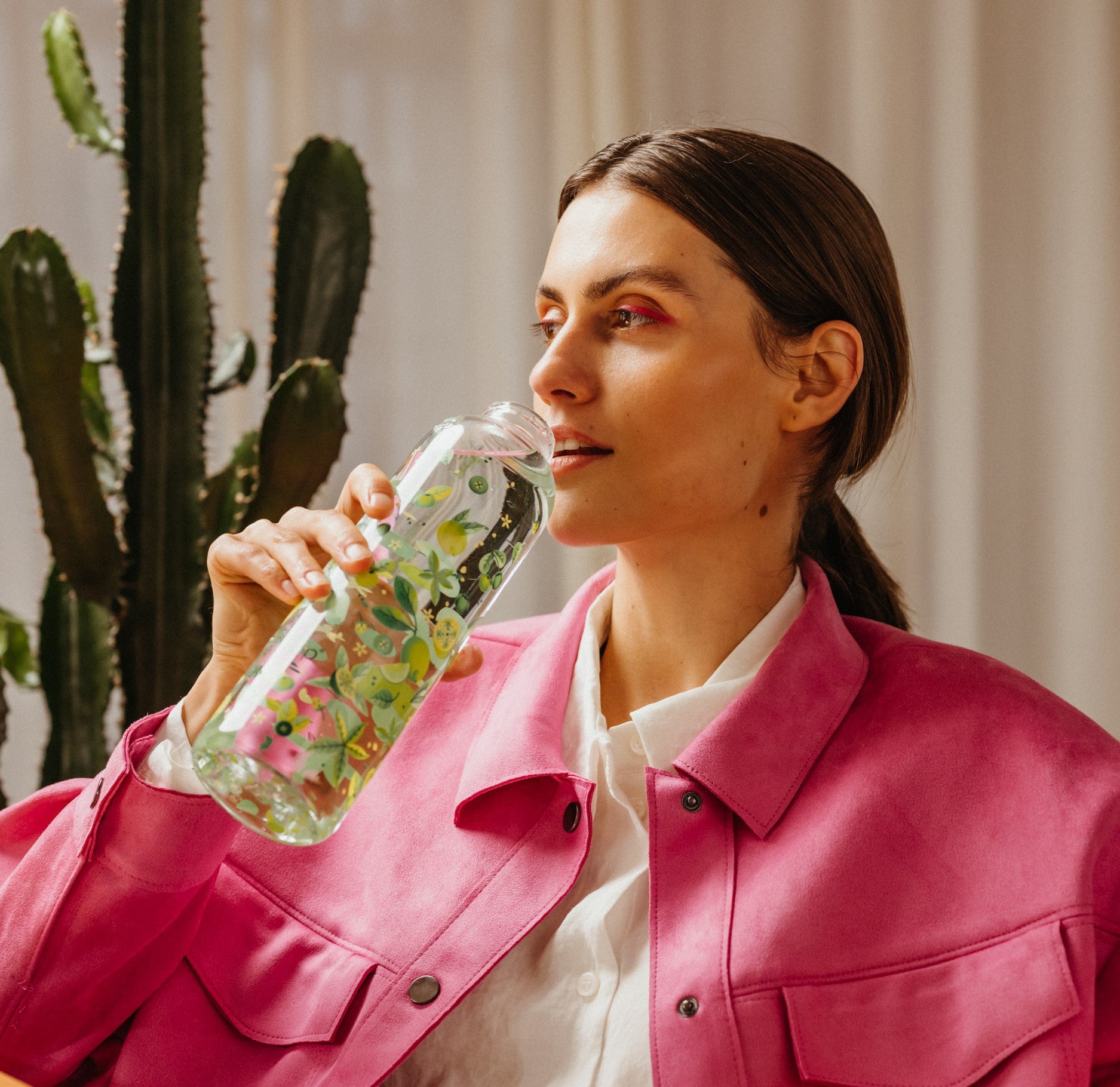 A woman drinking from a waterdrop® branded bottle.