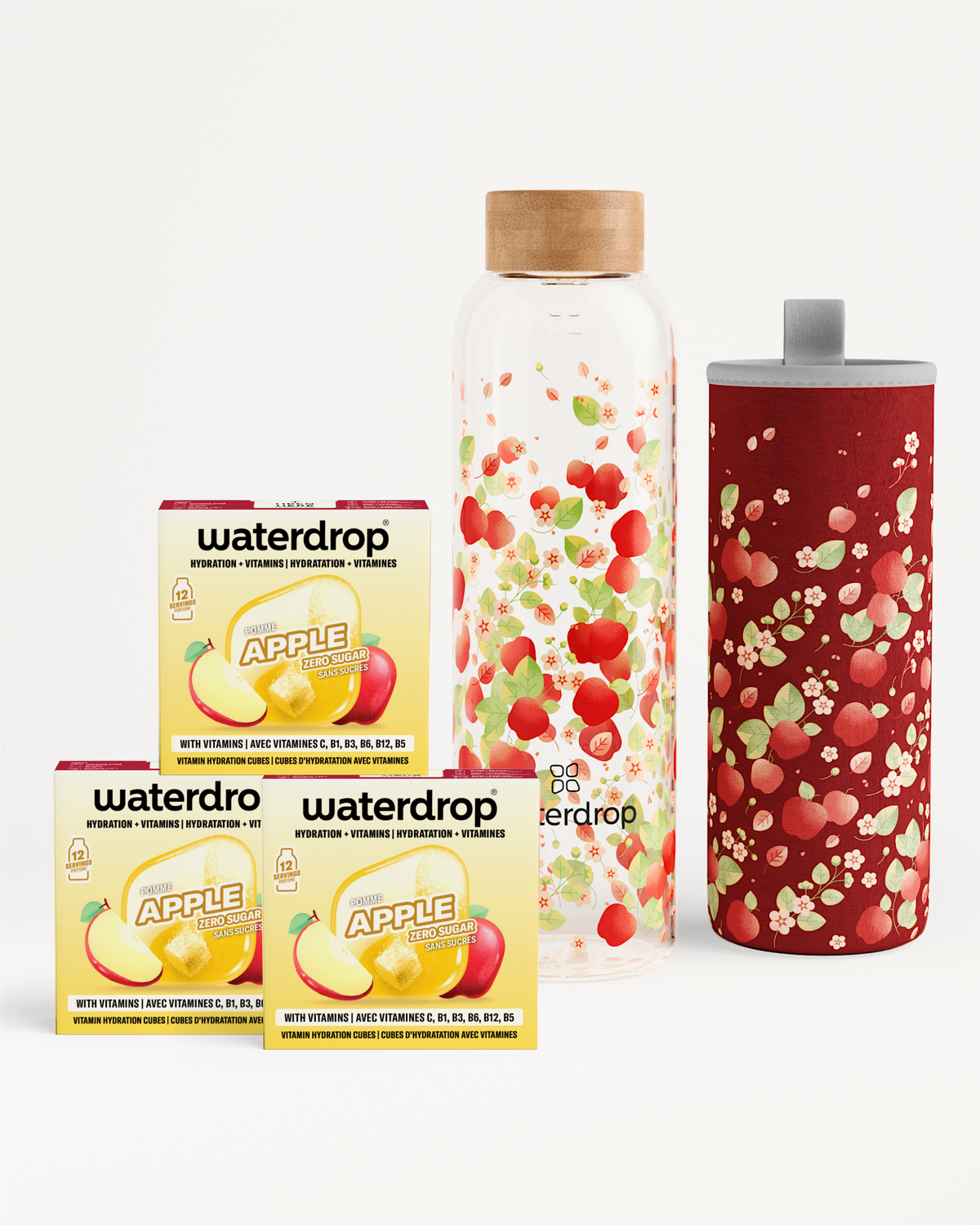 Assorted drink flavor enhancers including apple-flavored boxes, a fruit-filled glass bottle, and a red speckled tumbler.