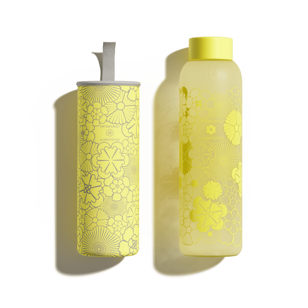 FLAIR Glass bottle with a yellow lid and floral label, designed by Viktor & Rolf, made from borosilicate glass for stylish hydration on the go.