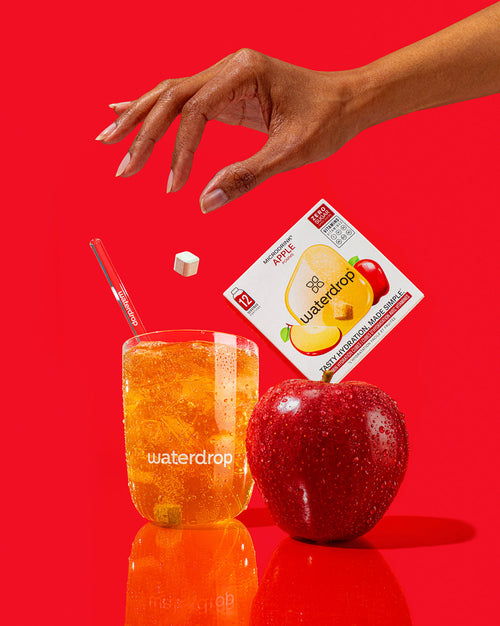 waterdrop® APPLE microdrink with glass tumbler, apple, and packaging.