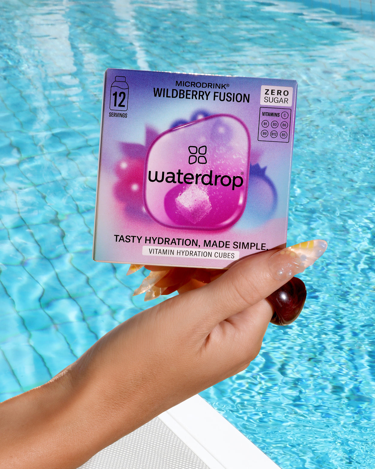 Hand holding WILDBERRY FUSION Microdrink cubes, zero sugar.