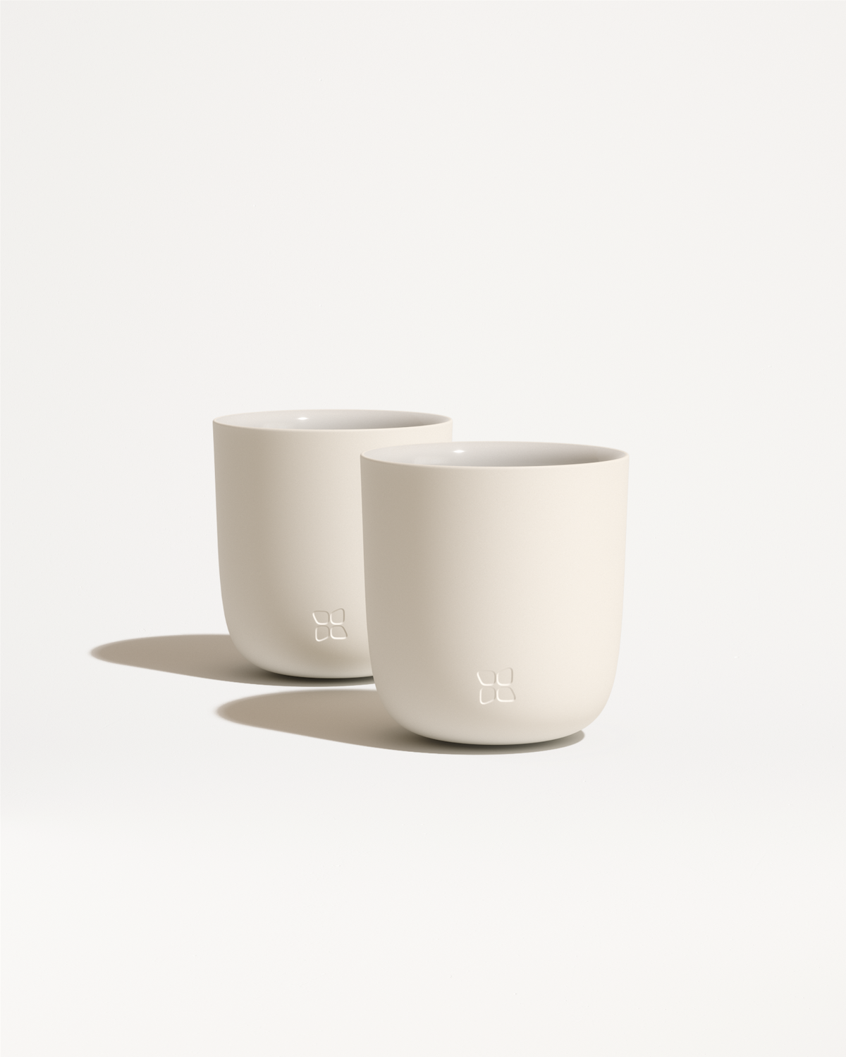 Porcelain Cups: Two double-walled porcelain cups with minimalist, rounded design, ideal for keeping drinks warm and hands cool.