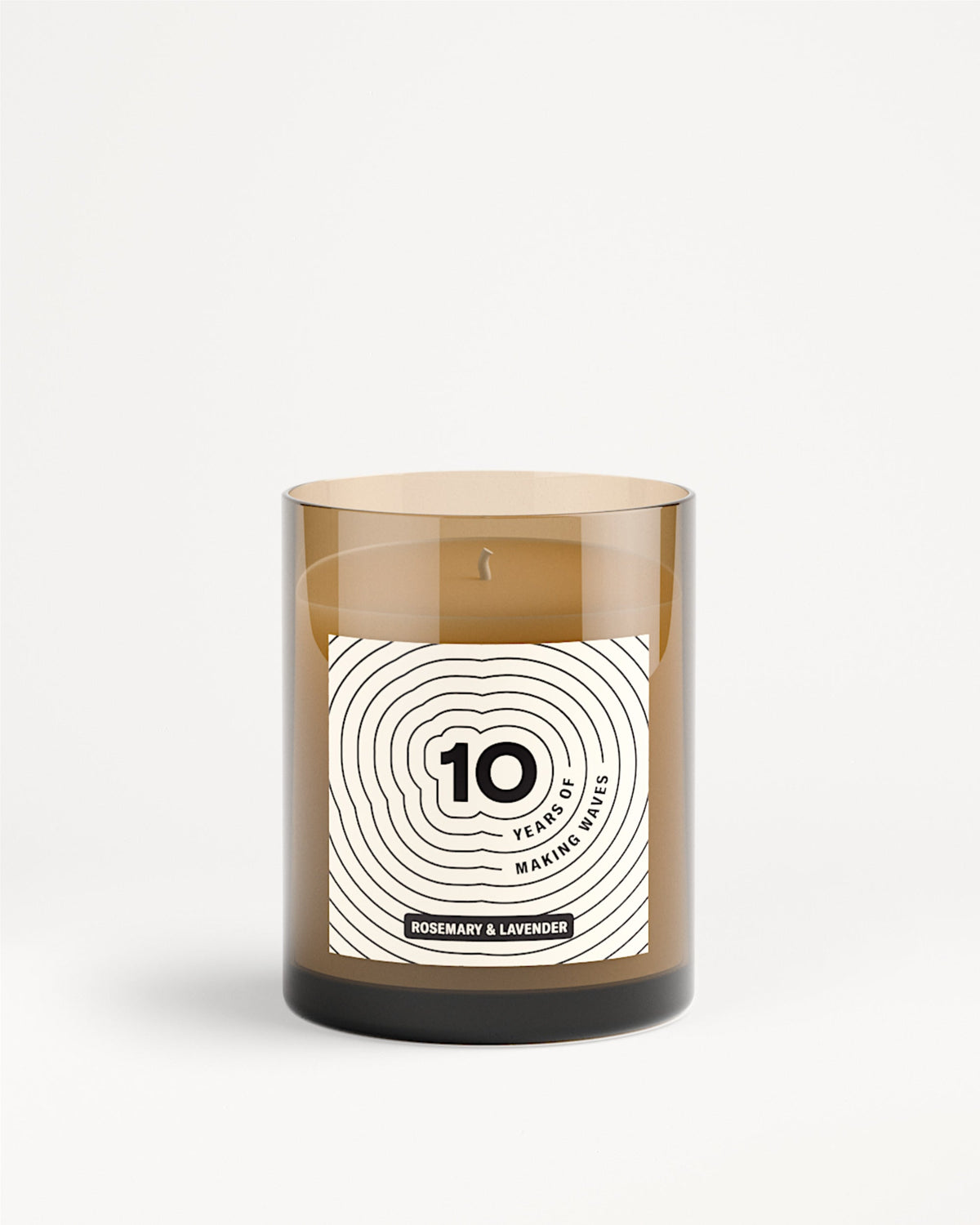 Brown glass candle jar with a white label featuring a concentric circle design.