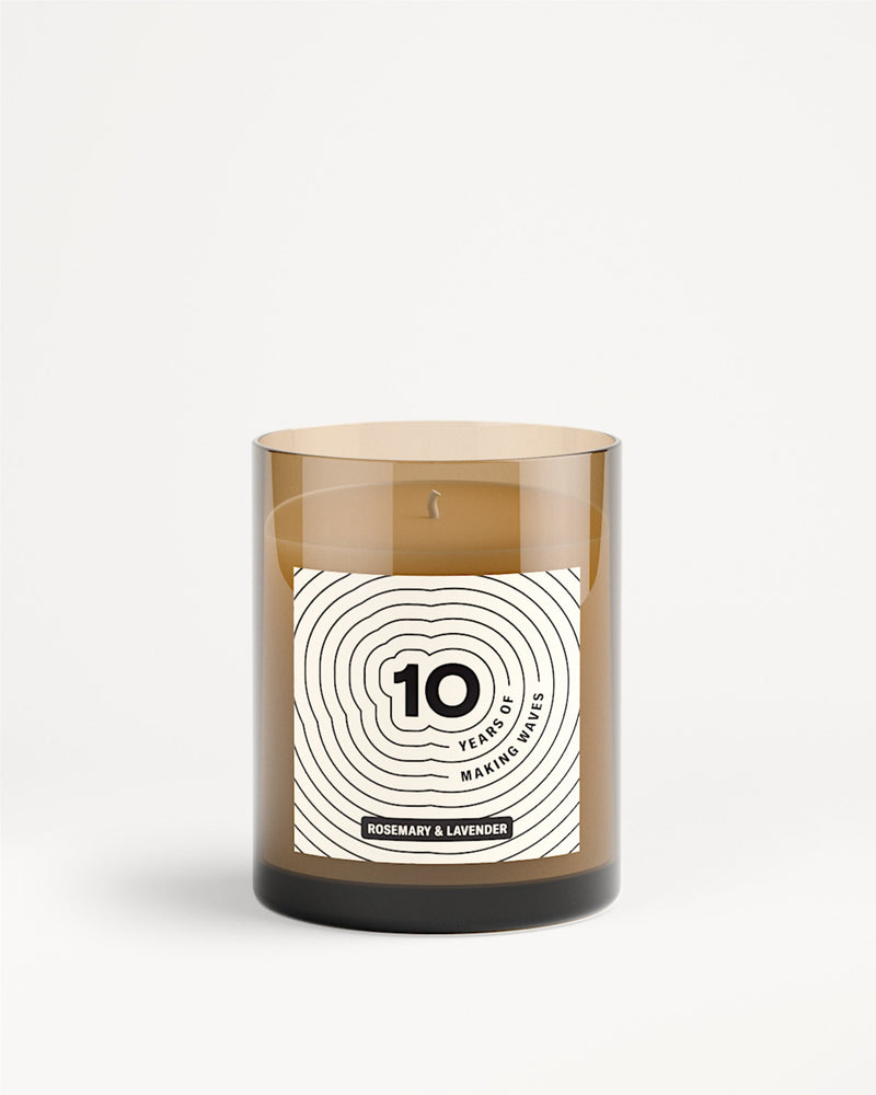 Brown glass candle jar with a white label featuring a concentric circle design.