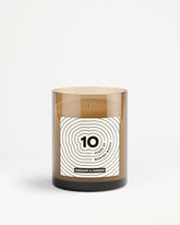 Brown glass candle jar with a white label featuring a concentric circle design.