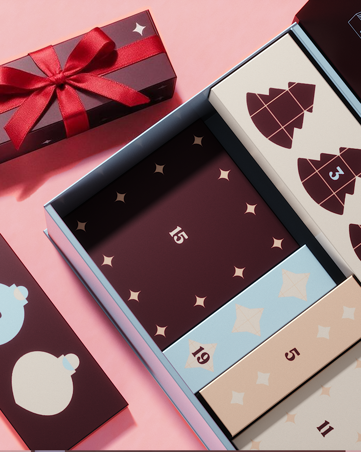 Advent calendar with decorative panels and a red gift box on a pink background.