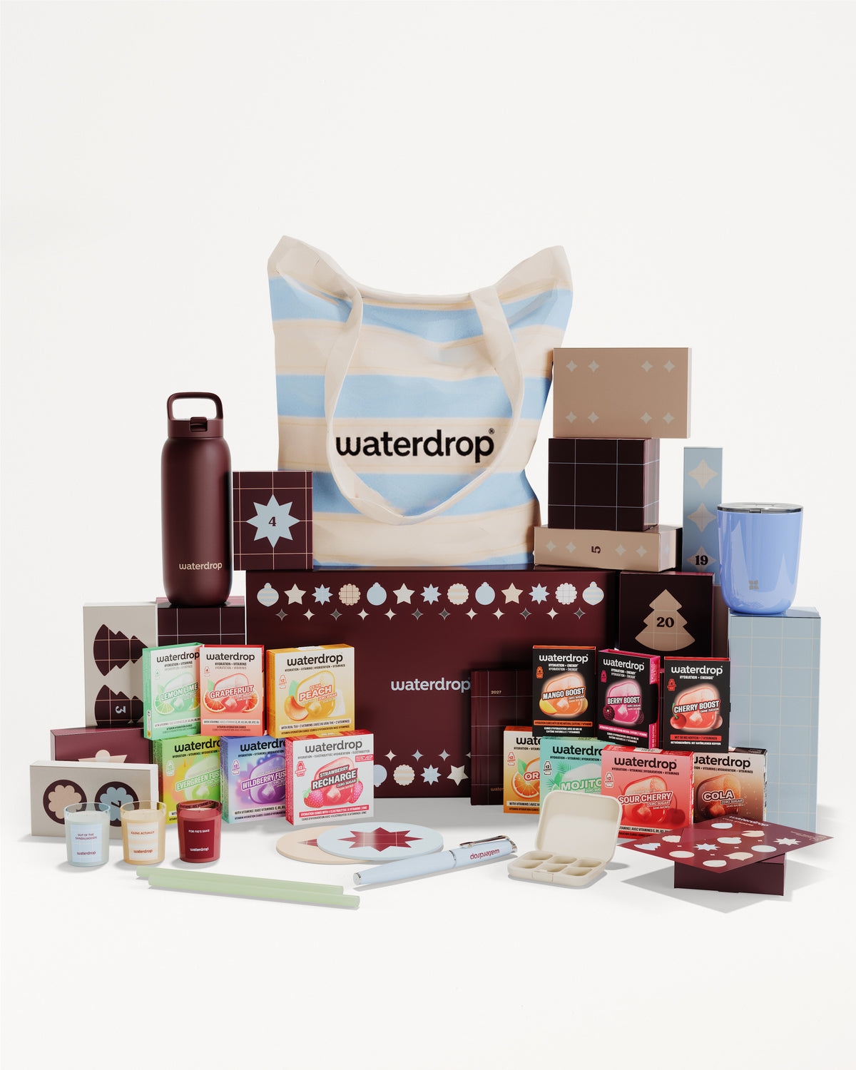 Assorted boxed products and containers arranged around a striped tote bag to form a gift set.