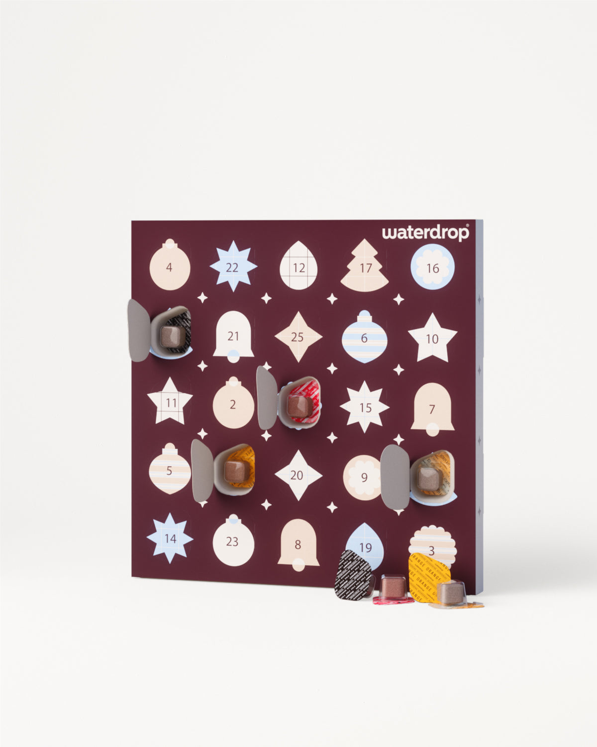 Advent calendar board with numbered doors and assorted chocolates.