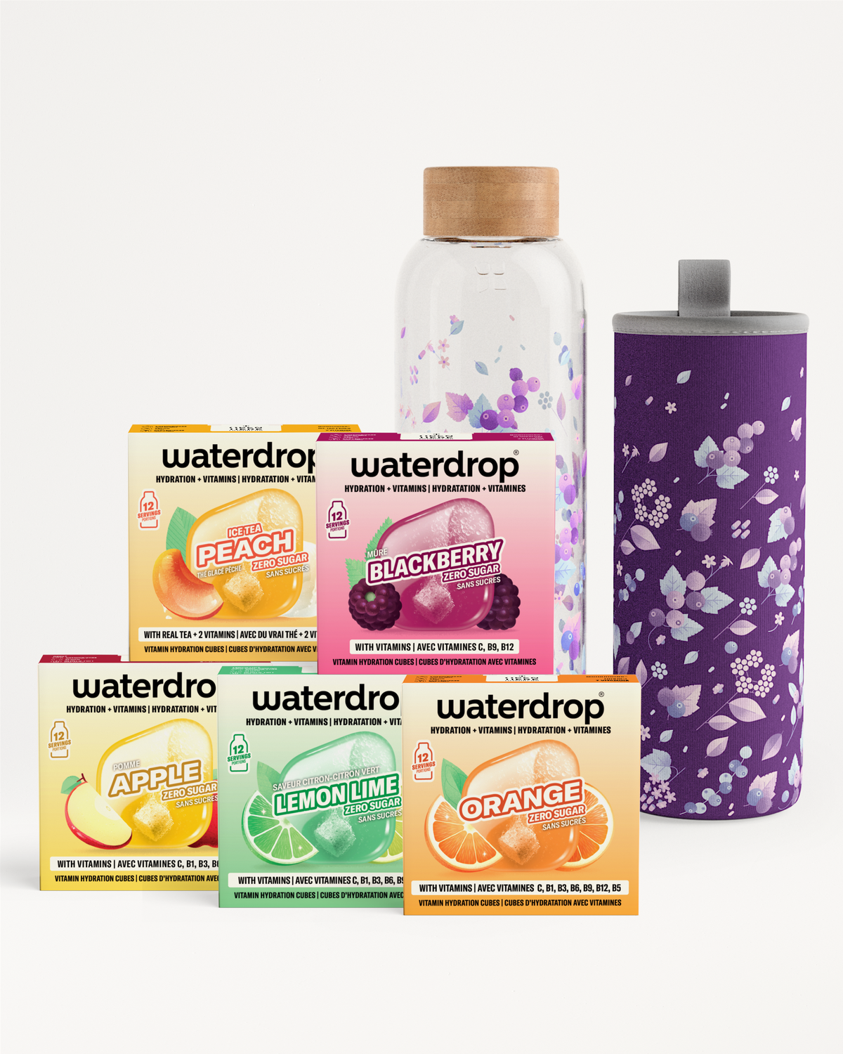 Assorted beverage flavor sachets in colorful boxes, plus a glass bottle with cork and a purple floral tumbler.