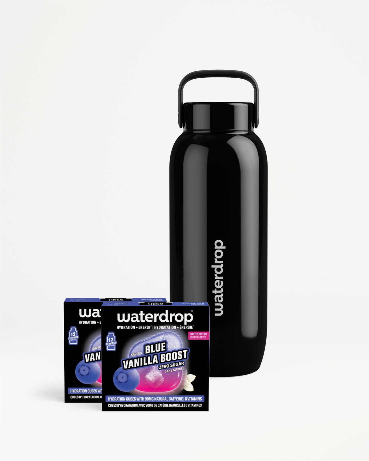 Matte black reusable water bottle with a carrying handle beside two flavor sachets.
