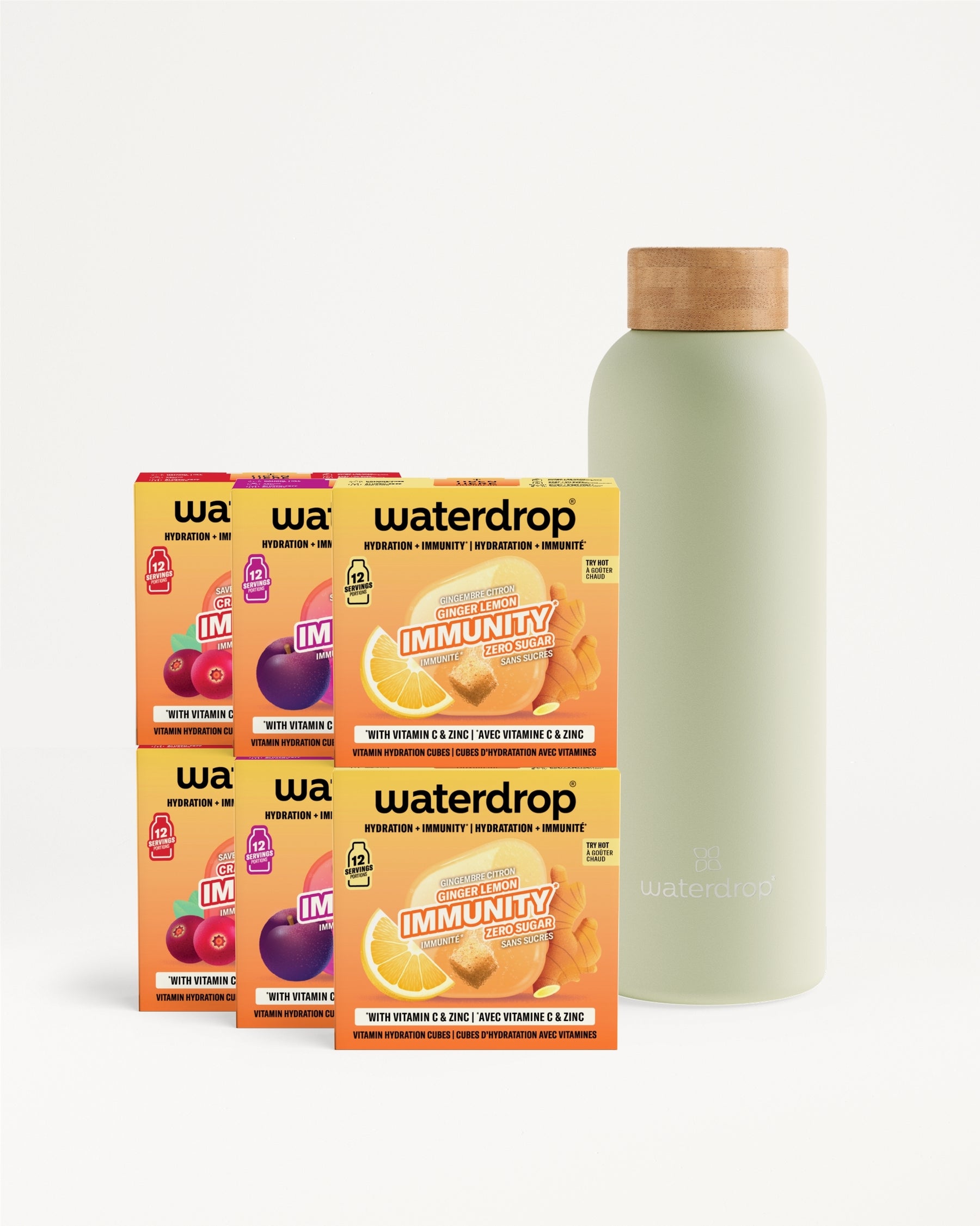 Six orange drink-mix boxes arranged beside a light green bottle with a cork cap.