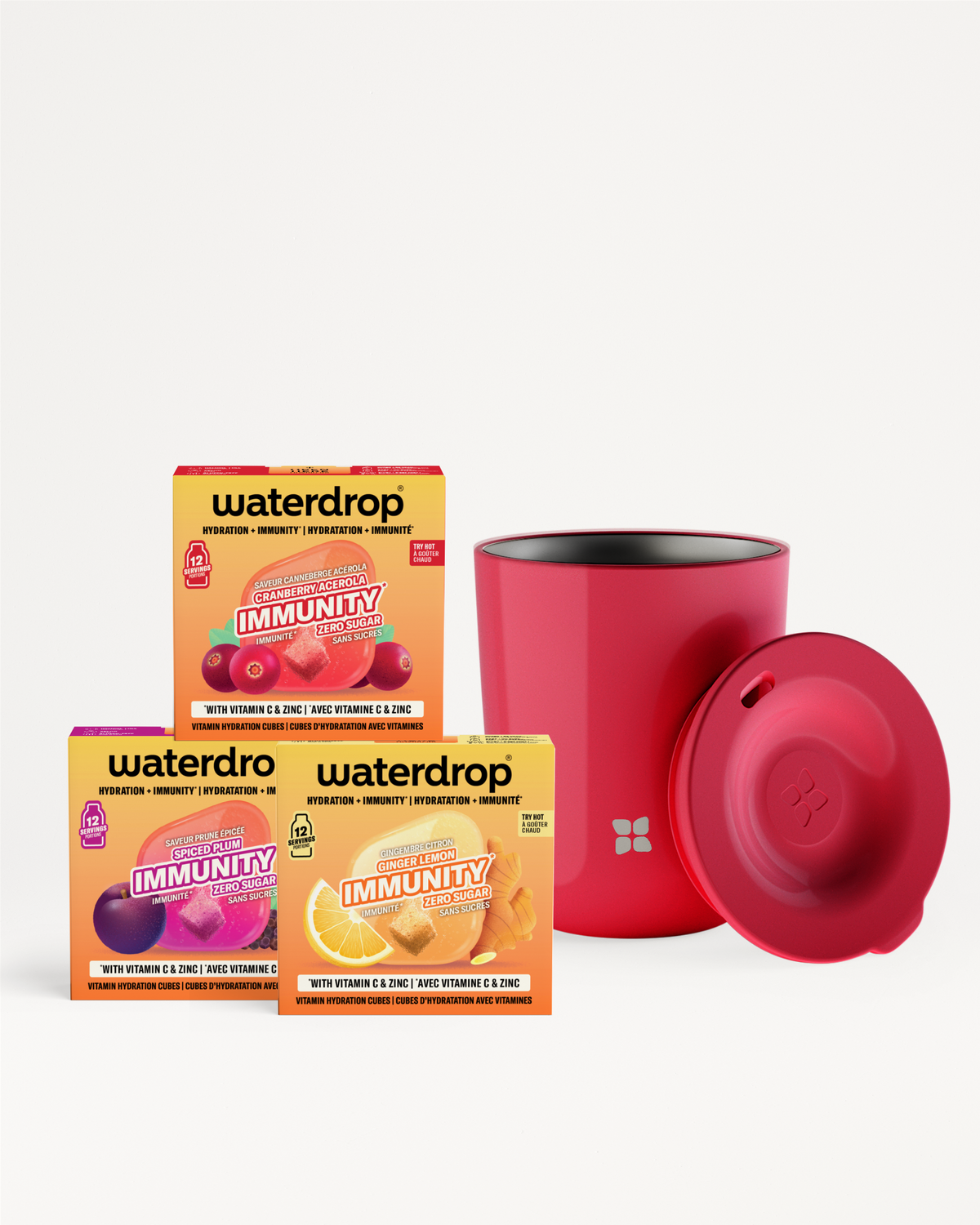 Three colorful vitamin sachet boxes arranged beside a red cylindrical bottle with a matching red lid.