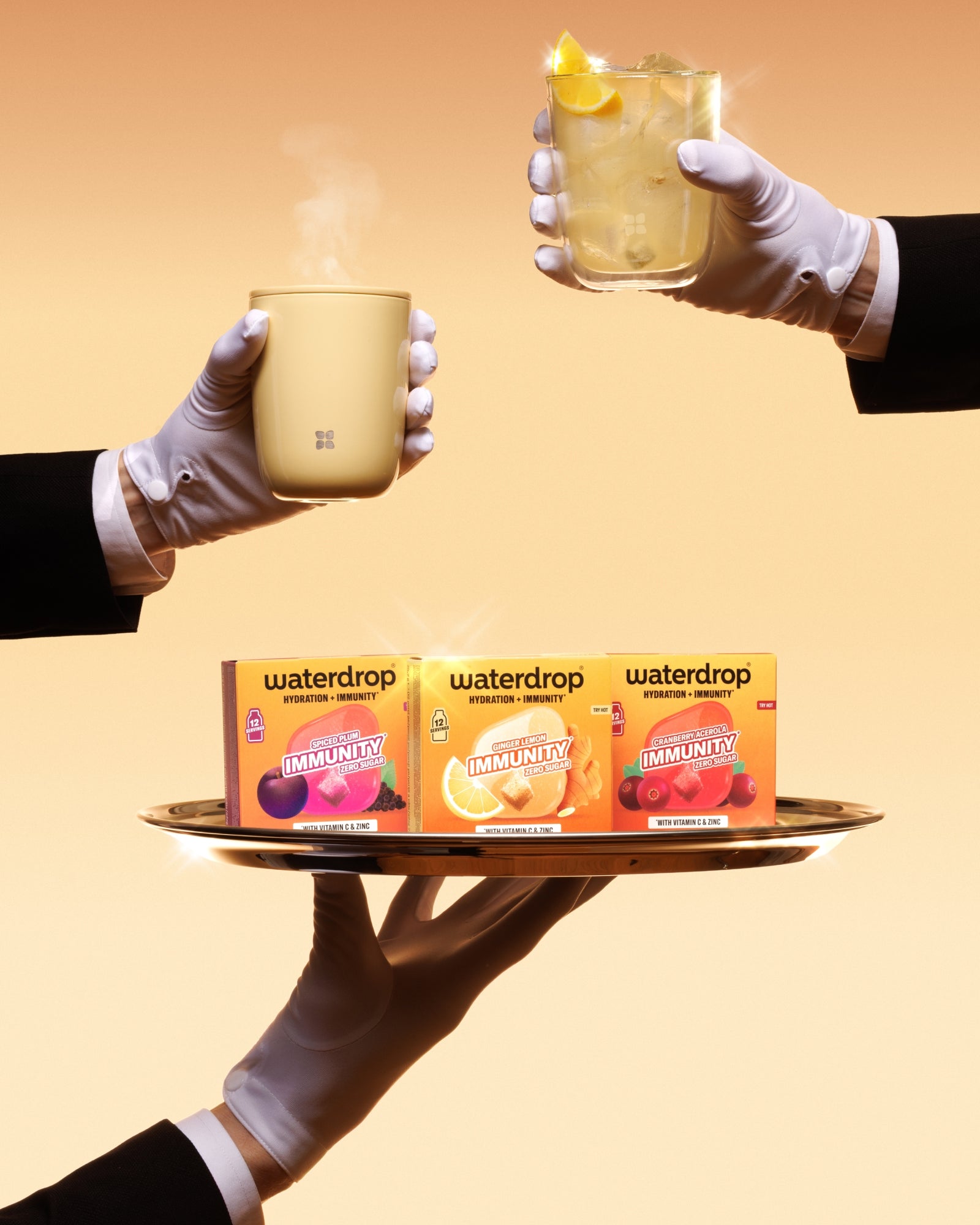 Gloved hands hold a tray displaying three Waterdrop boxes and two hot mugs against a warm orange background.