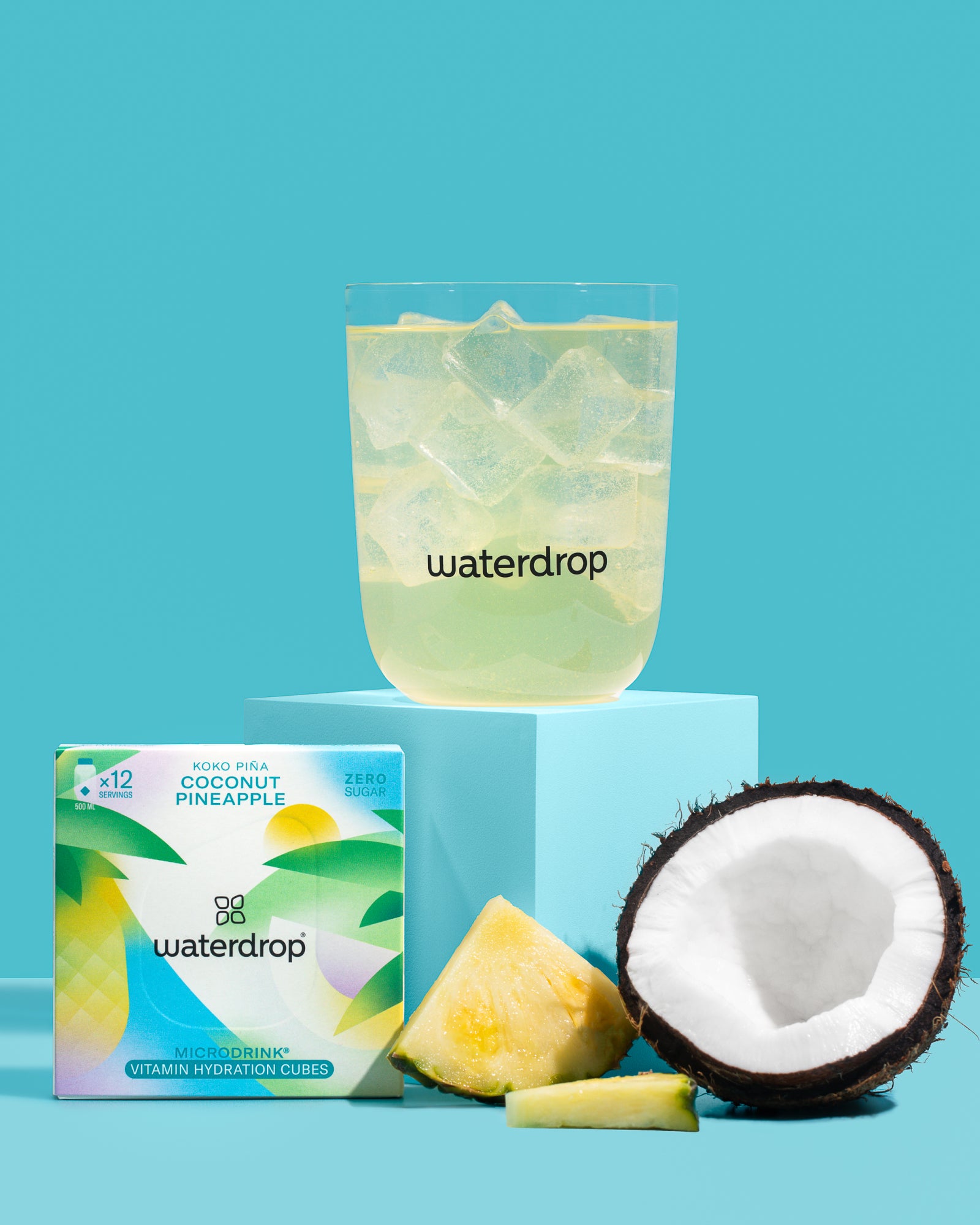 KOKO PIÑA product with a glass of iced water, coconut, pineapple slice, and a Waterdrop drink box.