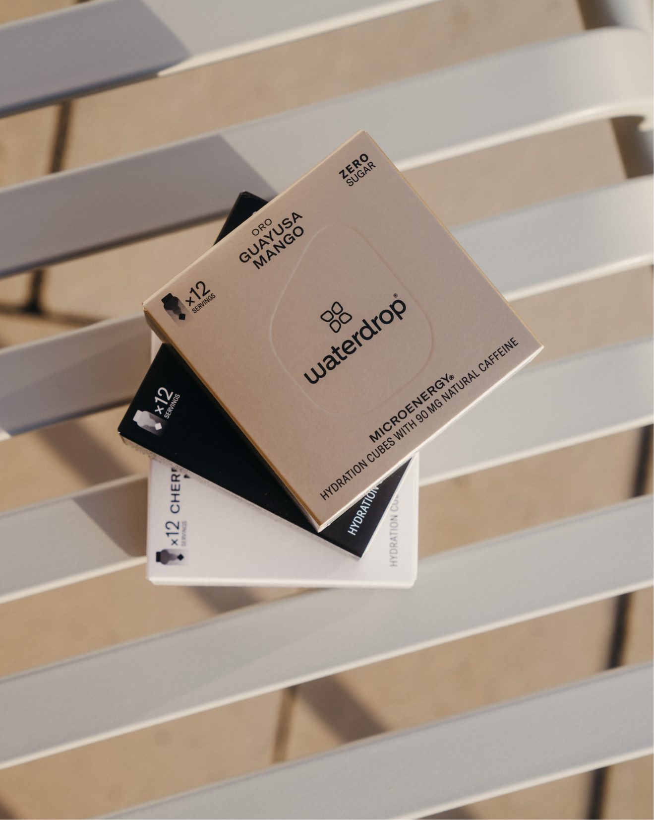 Stacked boxes featuring the Microenergy Set, including ORO, NERO, and SHIRO, on a bench, showcasing natural caffeine energy solutions.