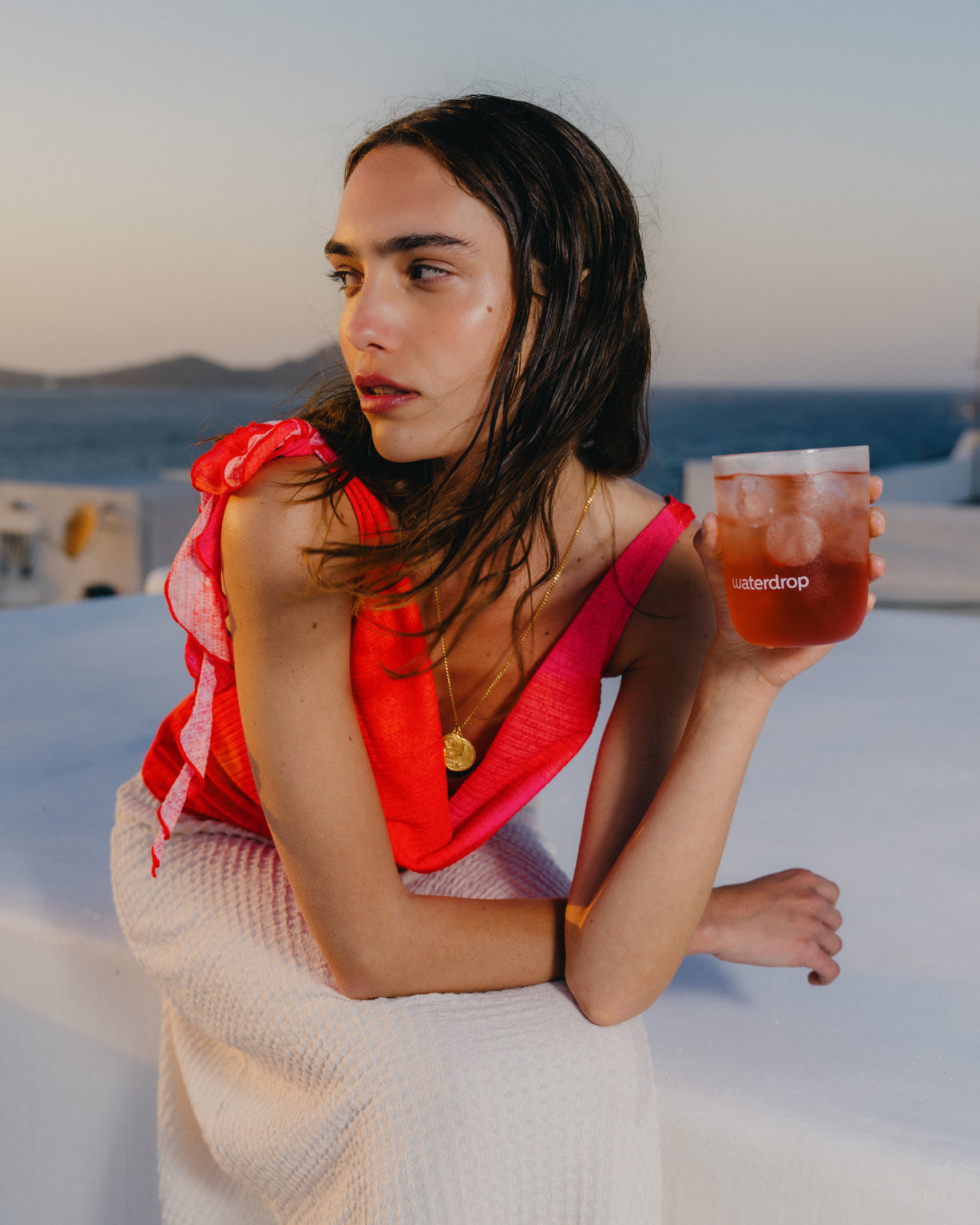 Woman enjoying ICE TEA RASPBERRY drink on a boat, capturing the refreshing essence of this sugar-free, tart, and subtly floral raspberry beverage.