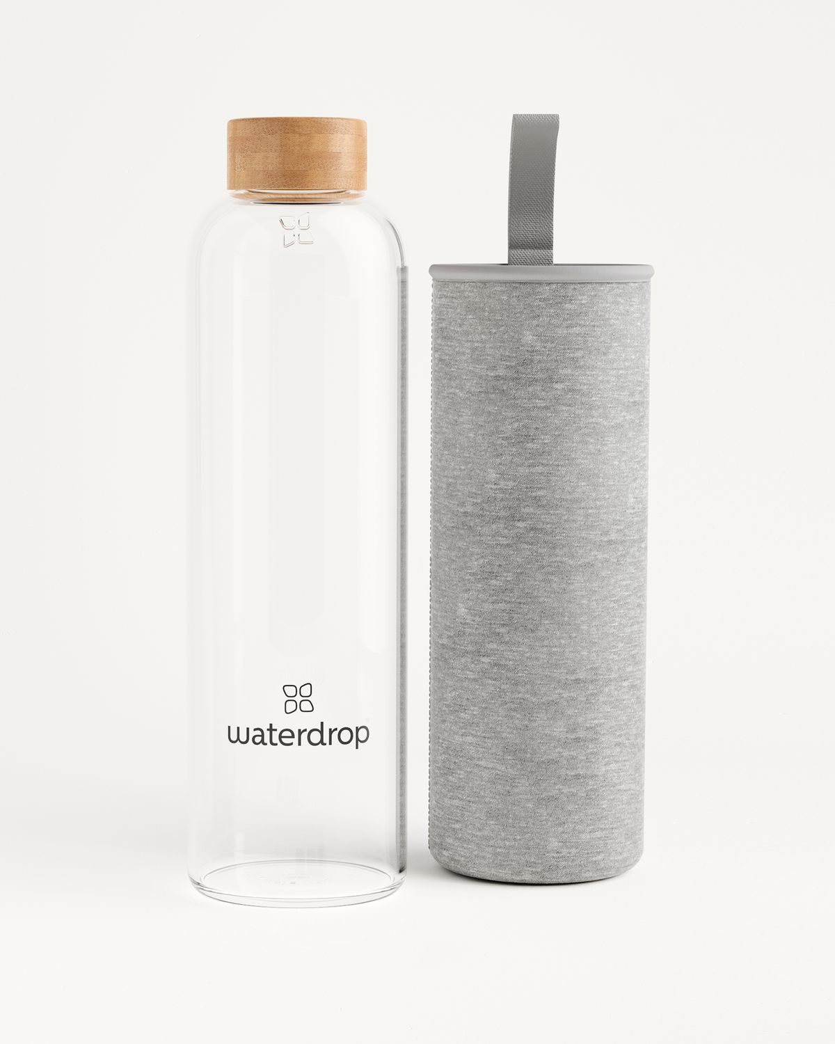 Clear Glass Bottle next to a cylindrical container, designed for elegant hydration, available in 400ml, 600ml, and 1L.