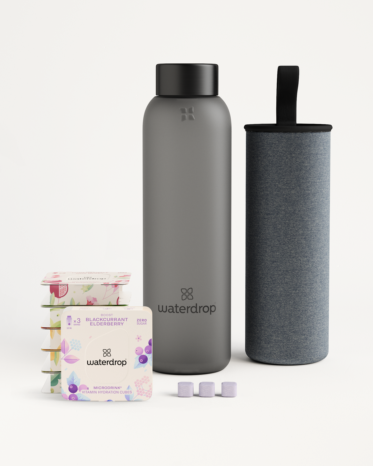 Starter Set Microdrink Glass featuring a grey borosilicate water bottle and accompanying case, alongside six 3-pack Microdrink flavor boxes.